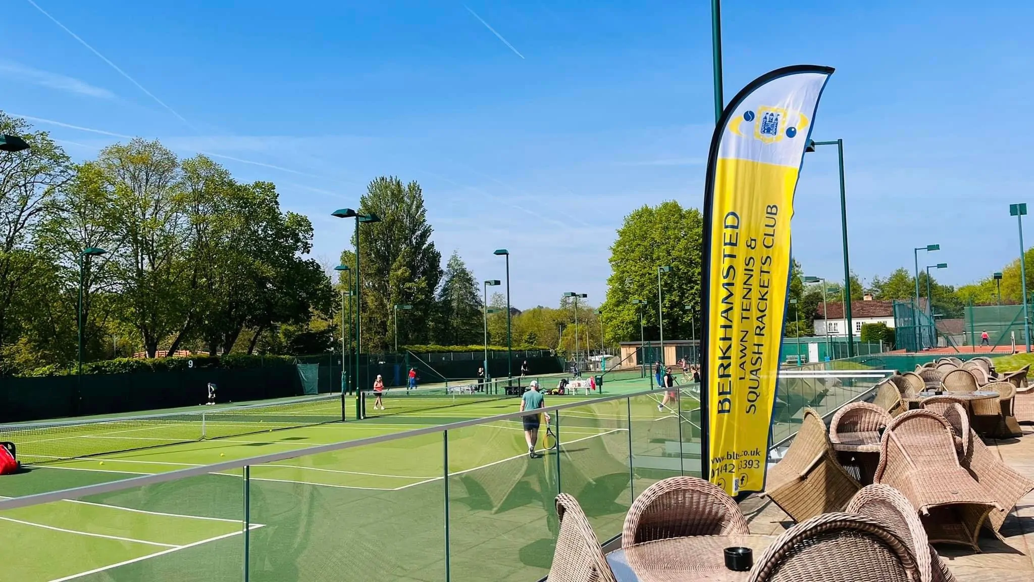 A view over tennis courts from a raised viewing balustrade.